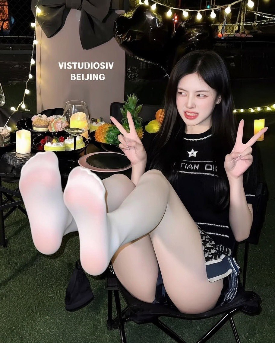 穿着黑色衬衫和白色袜子的女人为拍照。