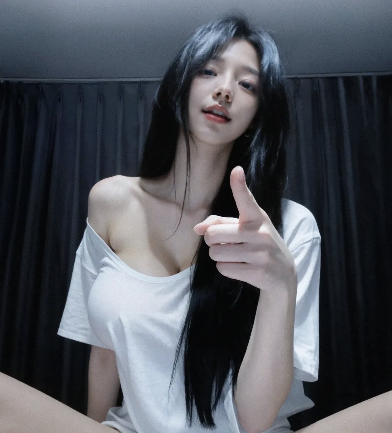 穿着白色衬衫的女人指向相机。