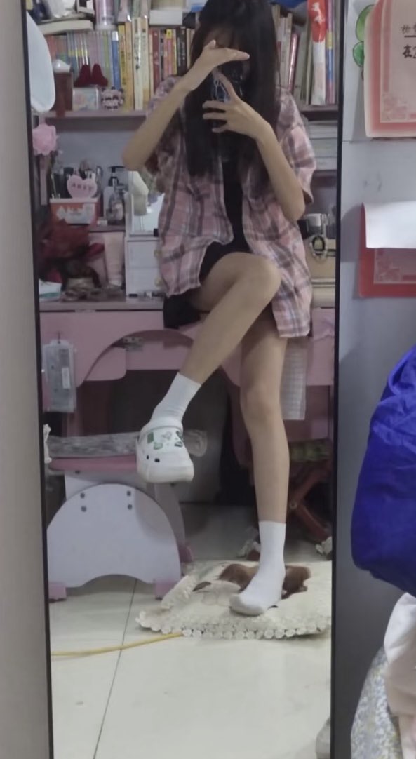 穿着粉红色的衬衫和白色袜子的女人为一张照片。