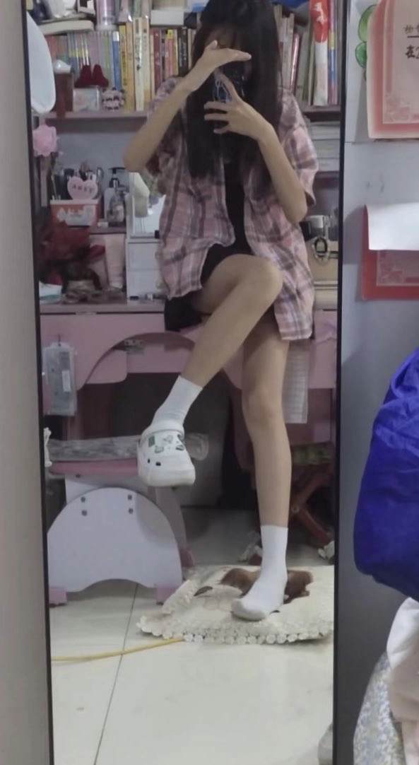 穿着粉红色的衬衫和白色袜子的女人为一张照片。