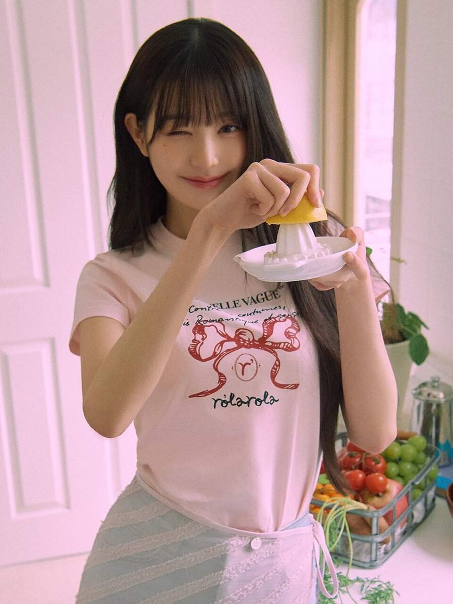 穿着粉红色衬衫的女孩站在厨房里。