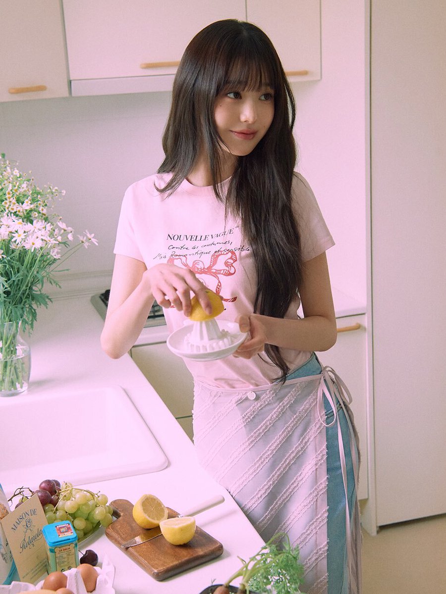 穿着粉红色衬衫的女孩站在厨房里。