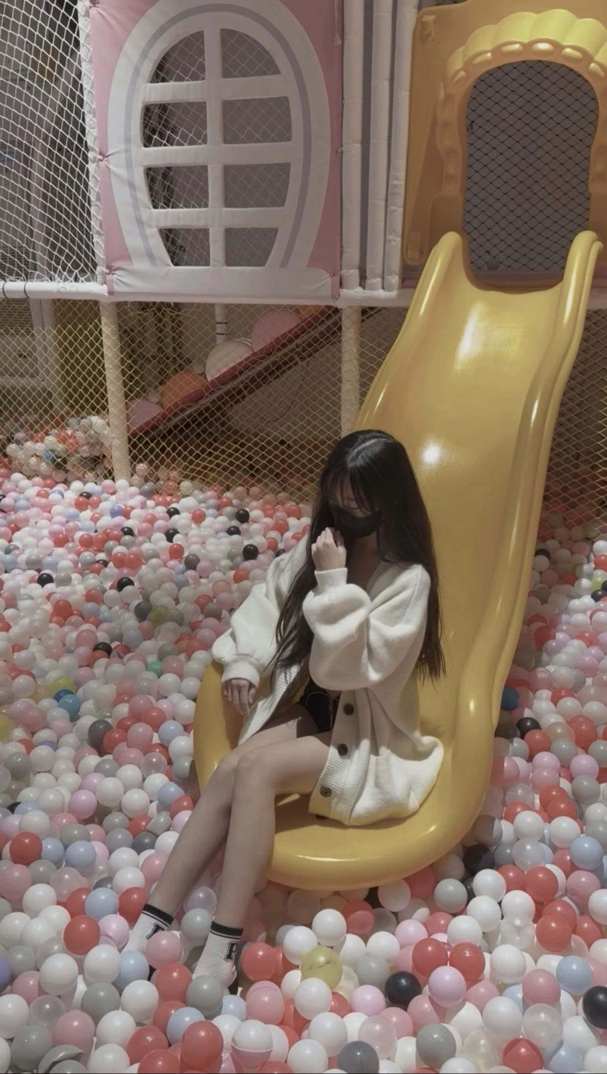 戴着面具的女人坐在一个黄色的滑板上。