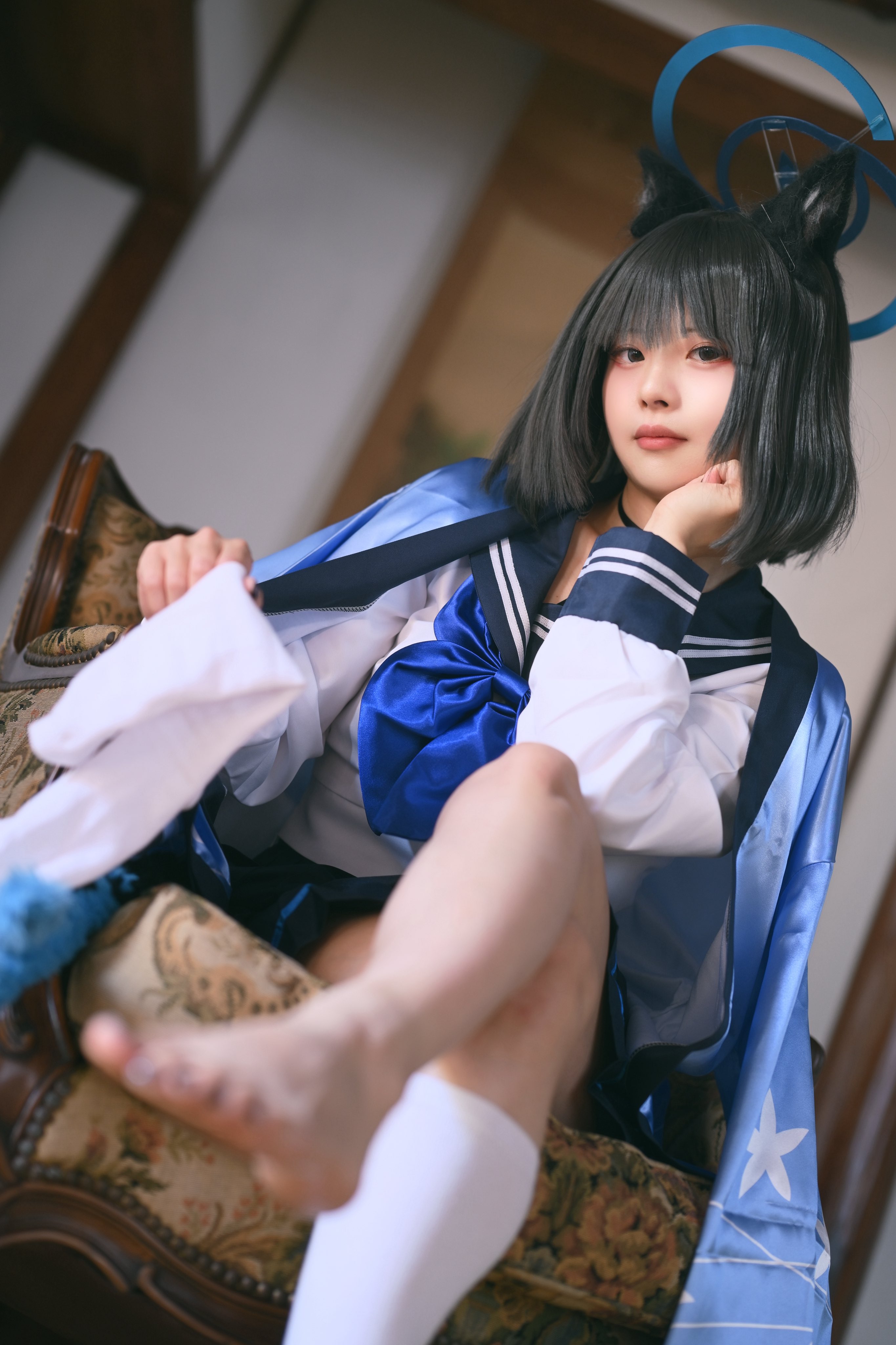 穿着蓝色和白色的水手服的女孩坐在椅子上。