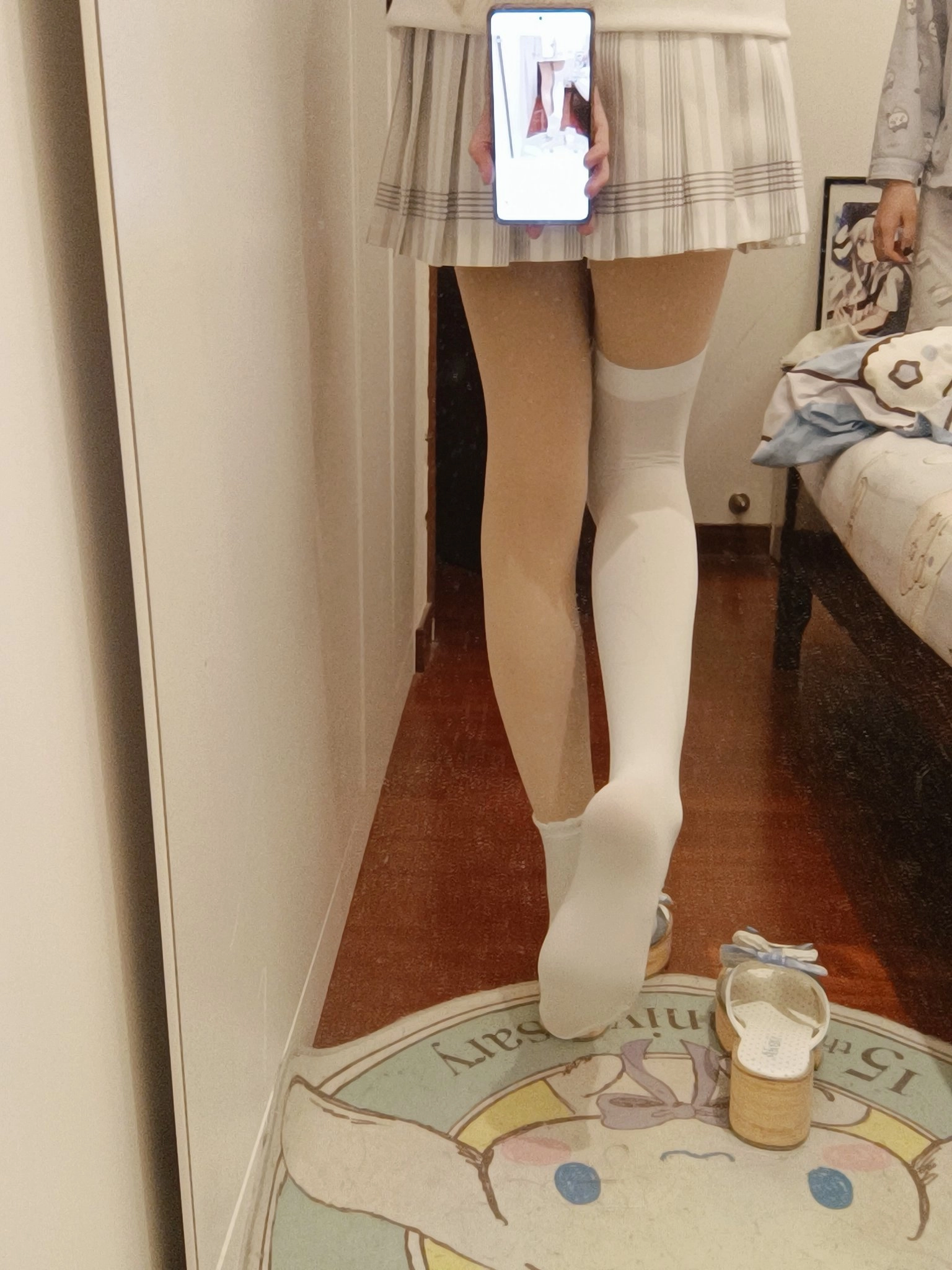 穿着白色裙子和白色袜子的女人拿着手机。