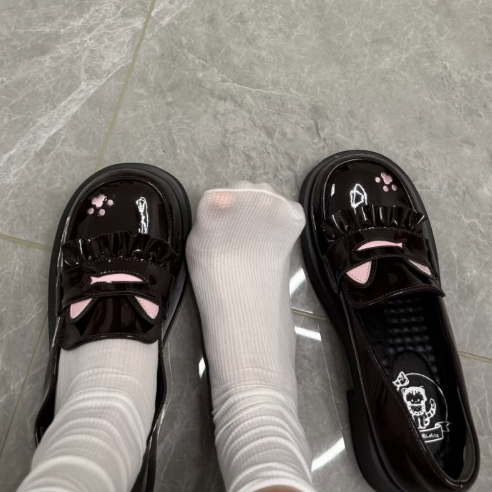 一双黑色的鞋子,上面有一只粉红色的猫。