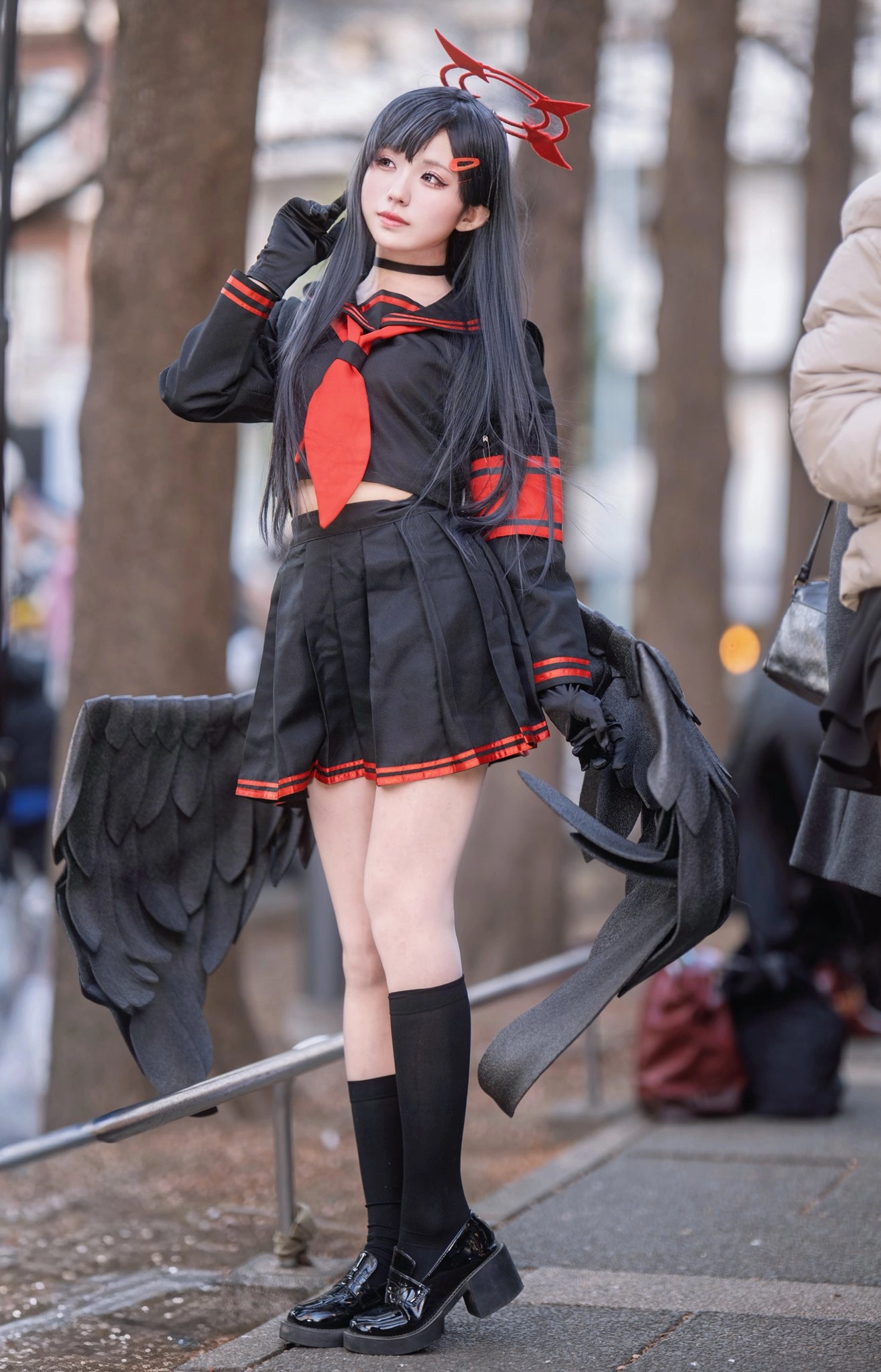 一位穿着黑色和红色的水手服的女人,手臂上有一只鸟翅膀。