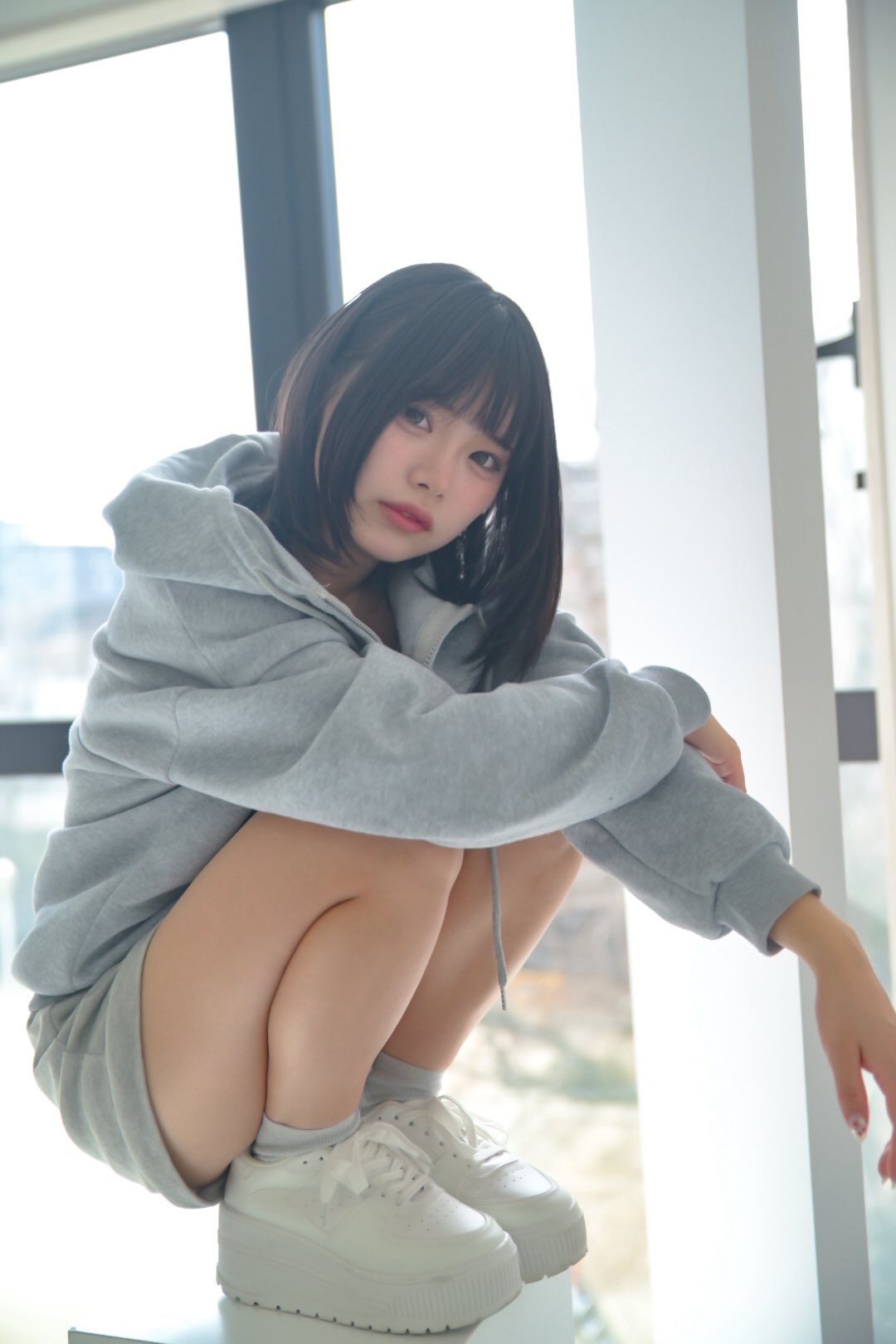 穿着灰色胡迪和灰色裤子的女人。