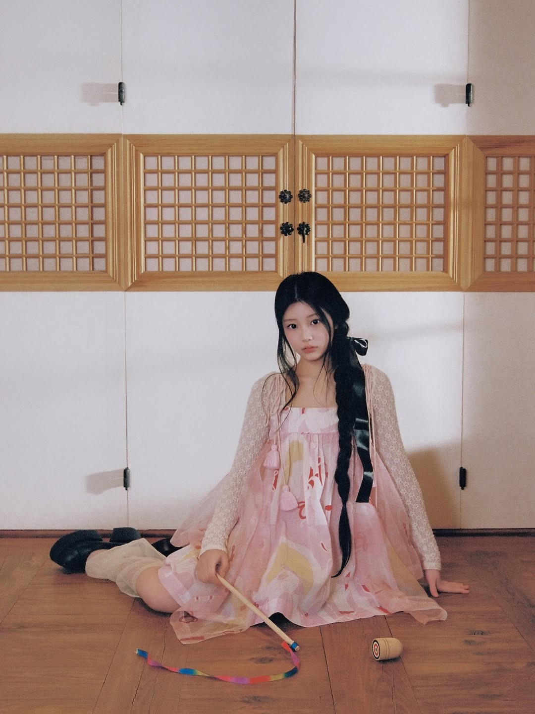 穿着粉红色衣服的女人站在墙前。