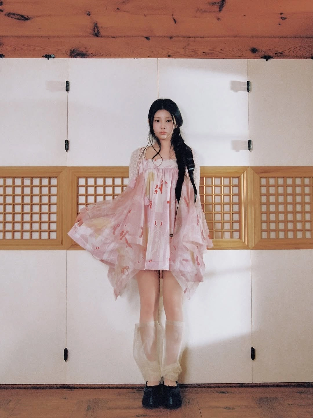 穿着粉红色衣服的女人站在墙前。