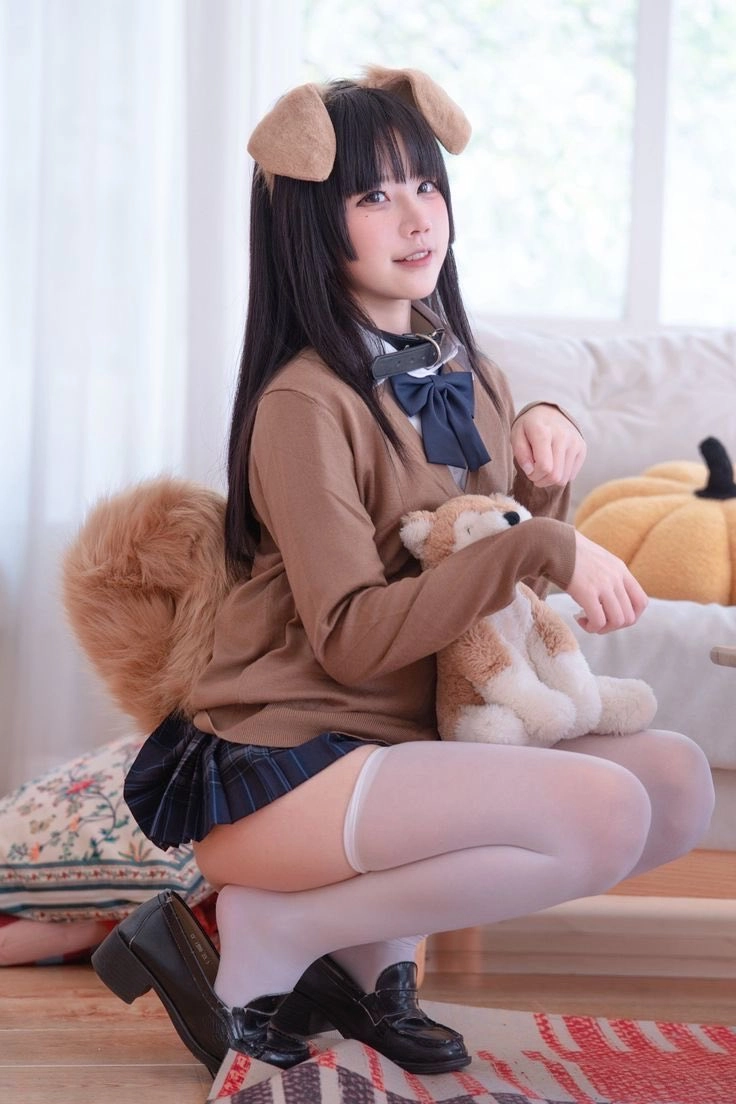 穿着棕色衬衫和猫服的女人抱着一只被填满的动物。