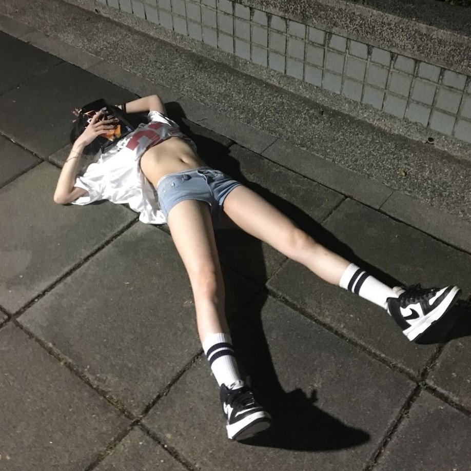 女人躺在地上,脱下衬衫。