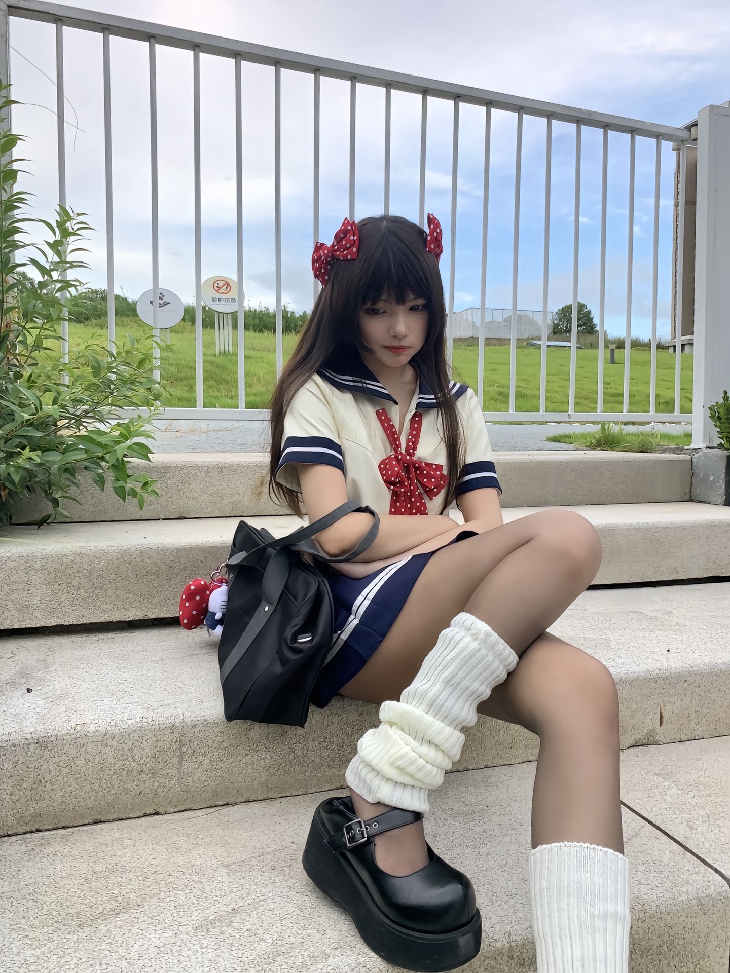 穿着水手服的女人坐在一块岩石上。