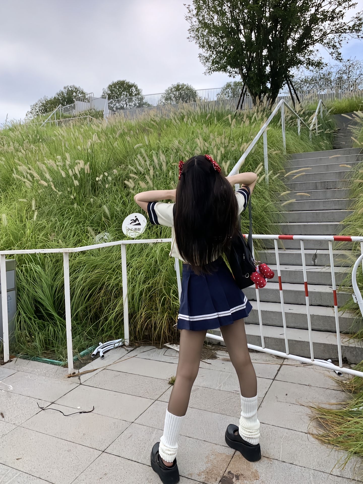 穿着水手服的女人坐在一块岩石上。