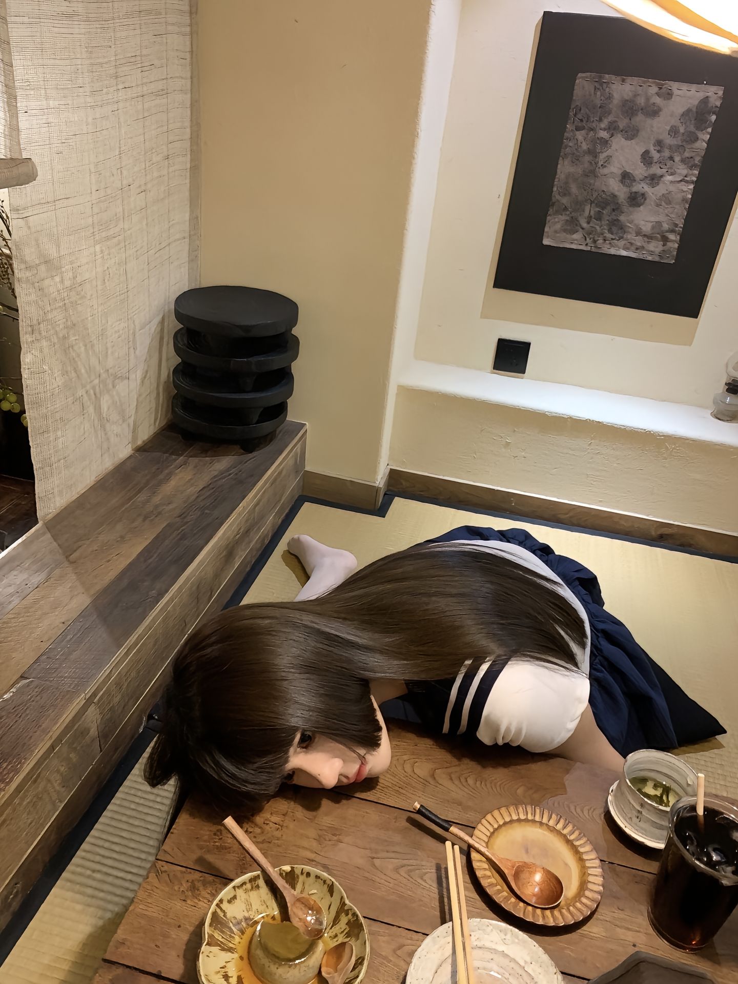 戴着一个水手的帽子和一个红色的弓的女孩坐在地板上。