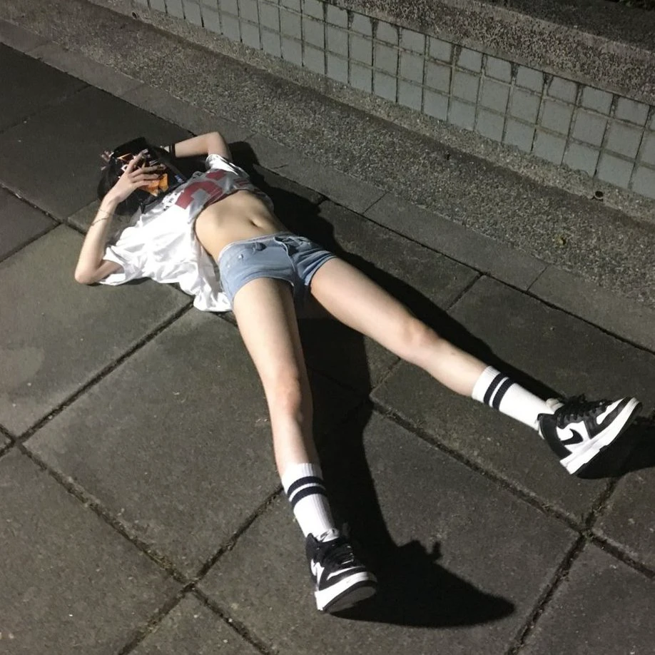 女人躺在地上,脱下衬衫。