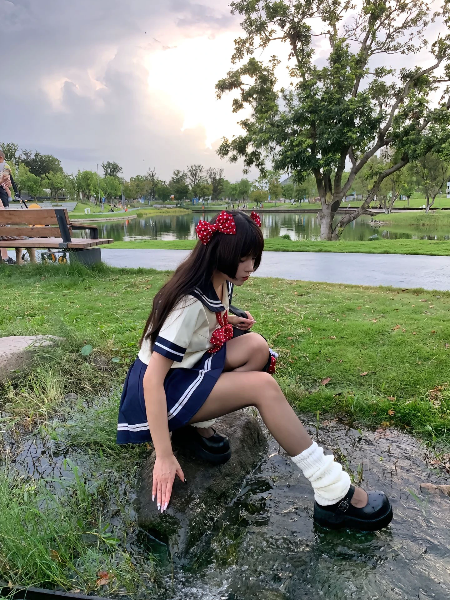 穿着水手服的女人坐在一块岩石上。