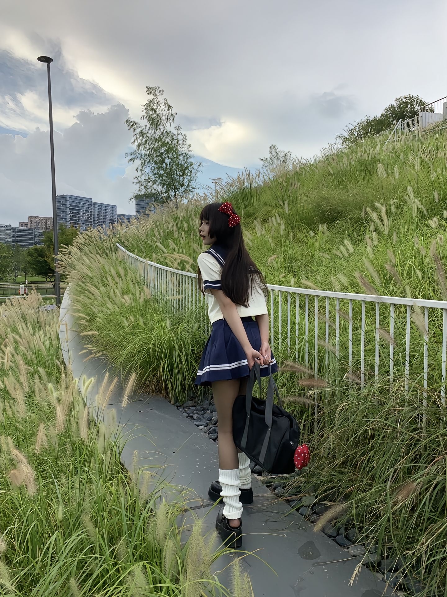 穿着水手服的女人坐在一块岩石上。