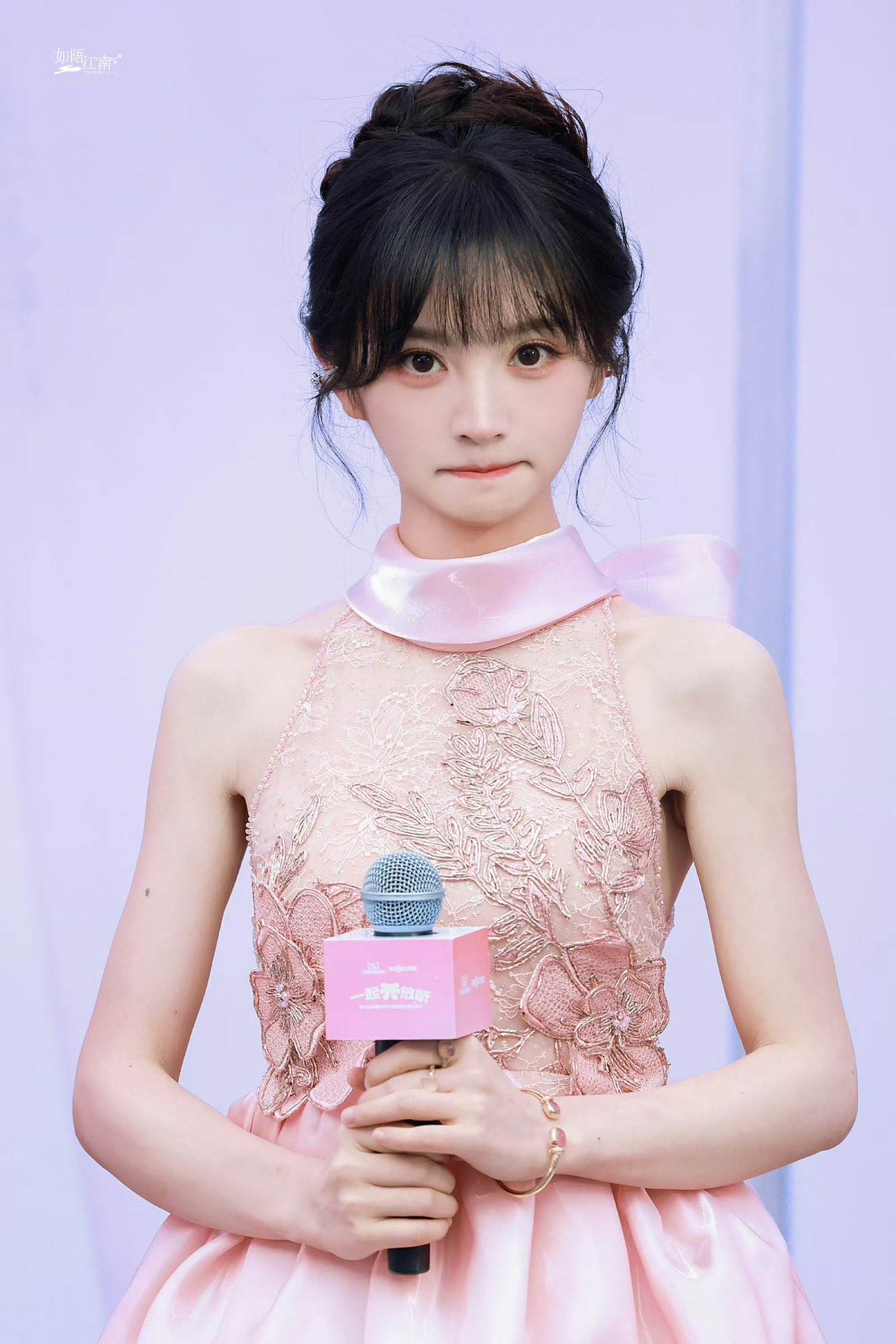 女人穿着粉红色的裙子,头上有弓。