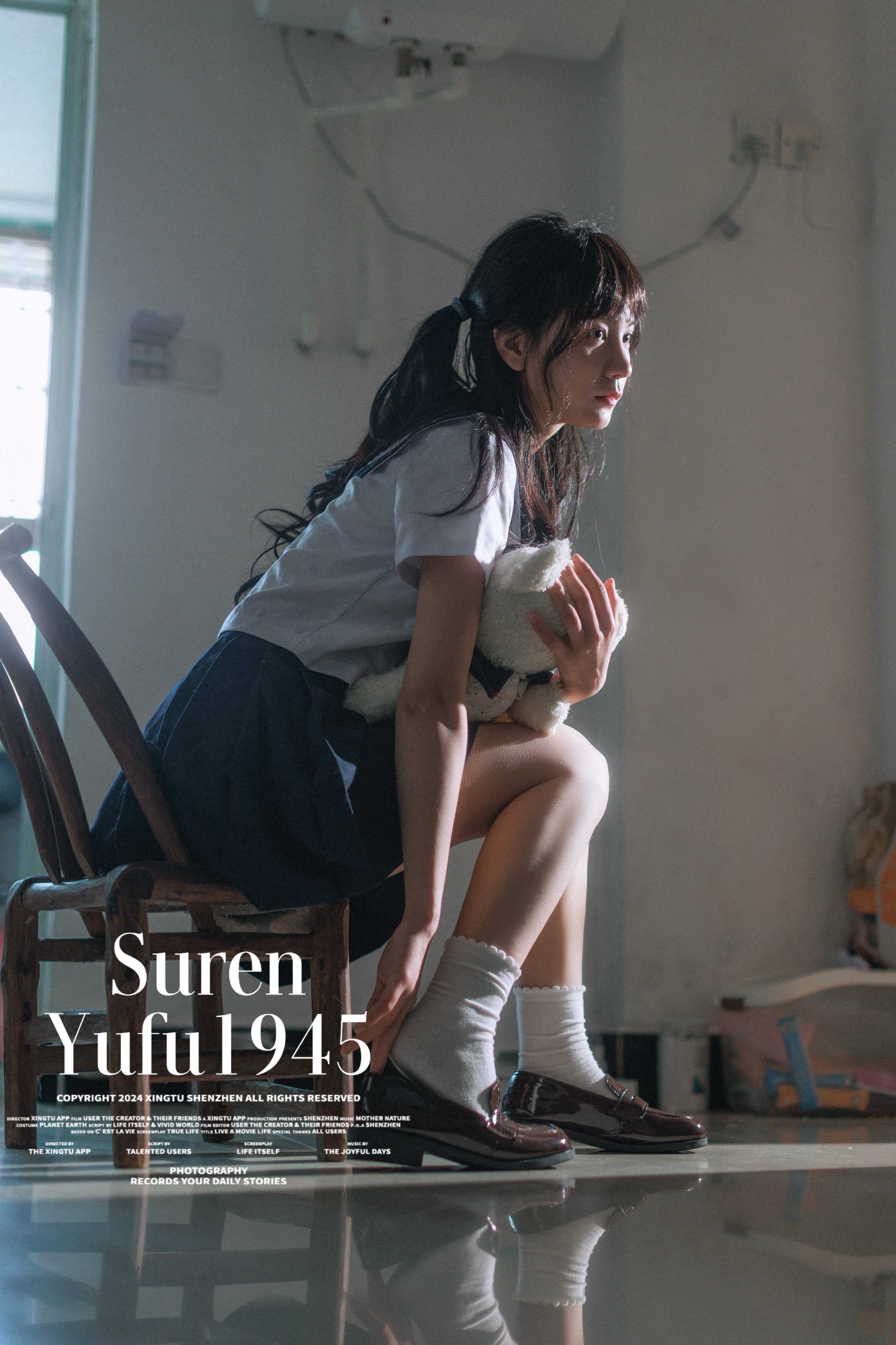 女孩坐在椅子上,抱着一只泰迪熊。