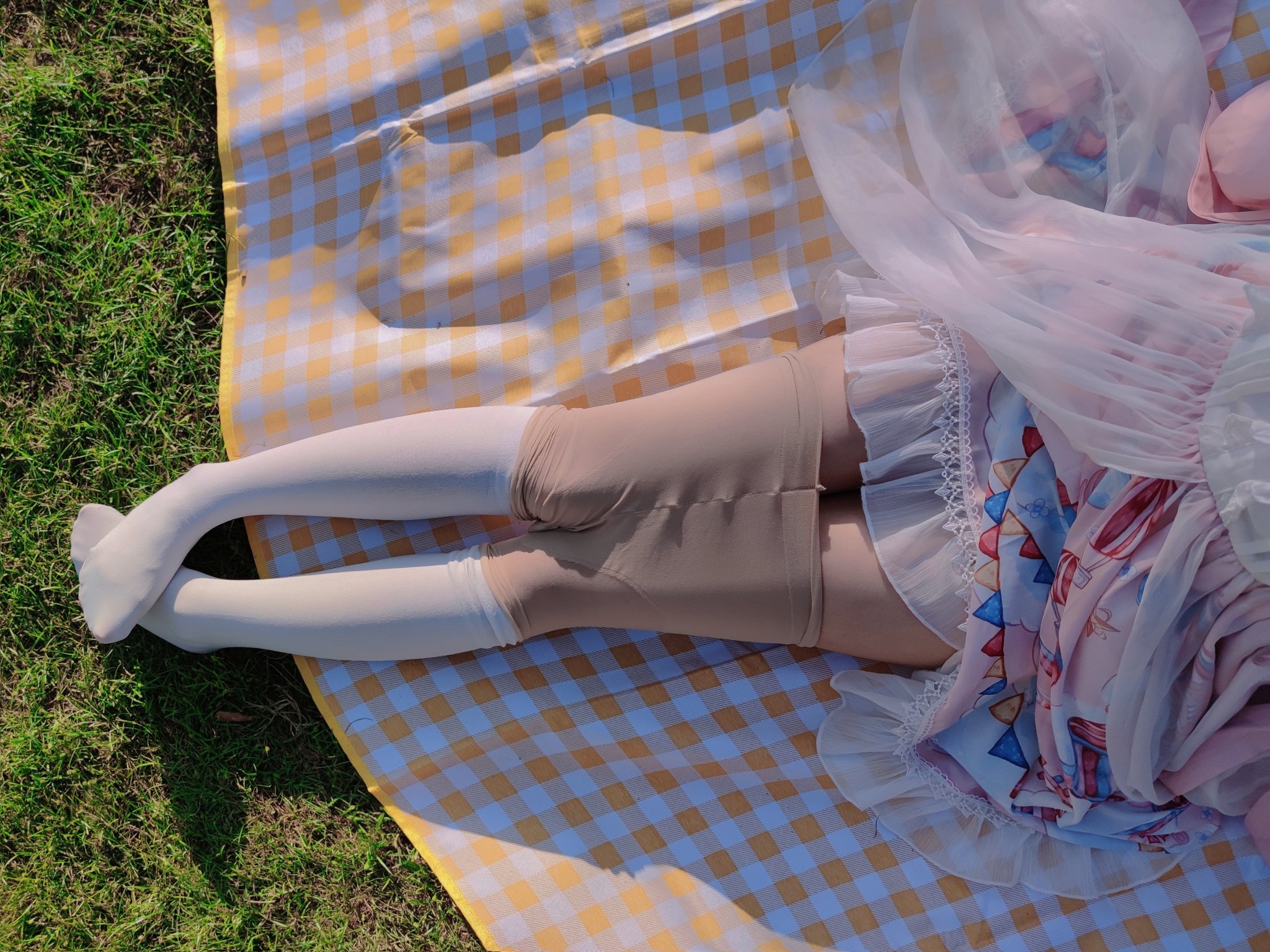 一位穿着白色袜子和鞋子的女人站在草地上。