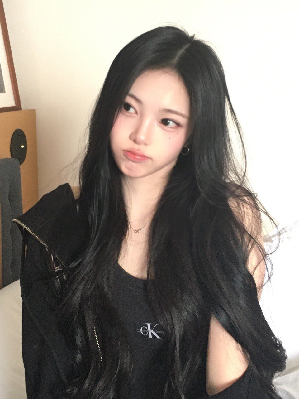 黑头发和黑衬衫的女孩正在制作一个有趣的面孔。