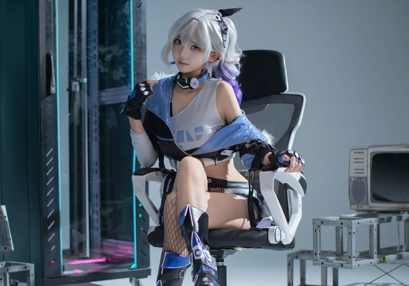 穿着蓝色和白色服装的女人坐在椅子上。