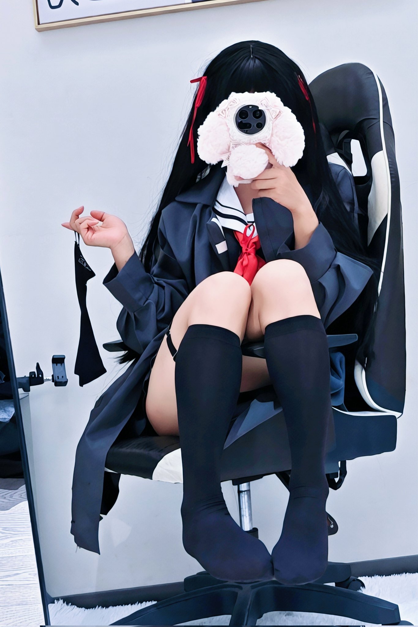 穿着黑色外套的女孩,抱着一只粉红色的动物。