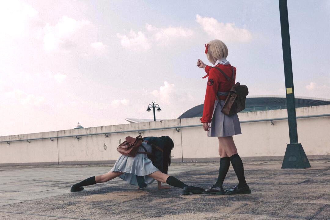 穿着红色衣服的女人指向另一个女人,她正在握手。