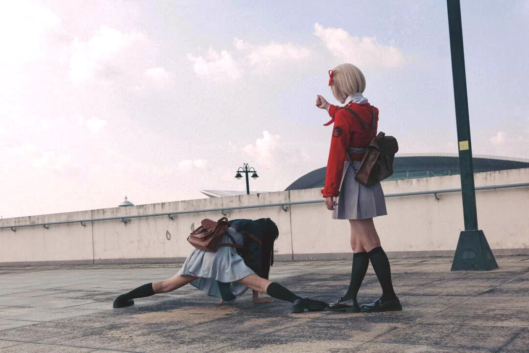 穿着红色衣服的女人指向另一个女人,她正在握手。