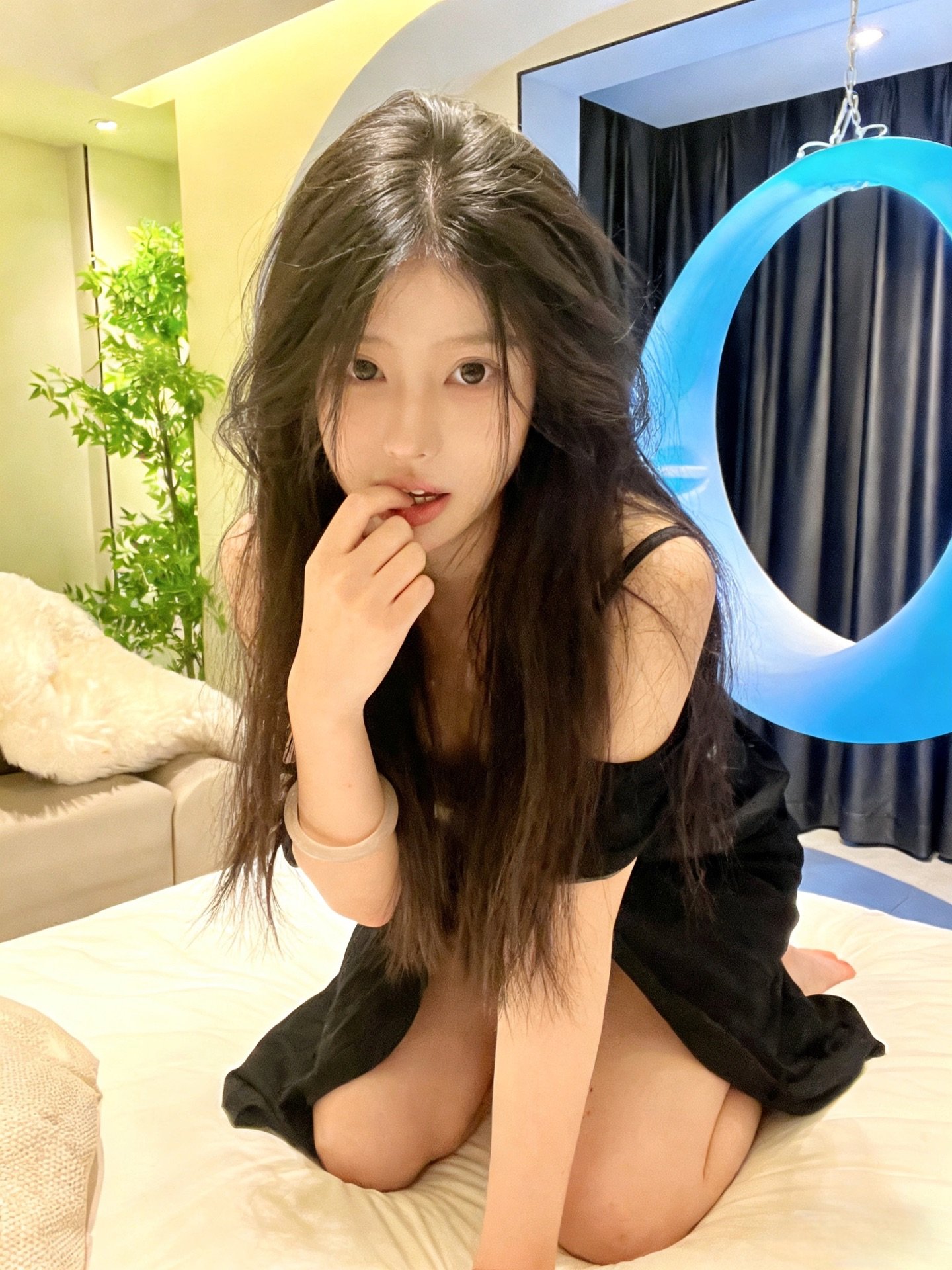 长头发和黑裙子的女人坐在床上。