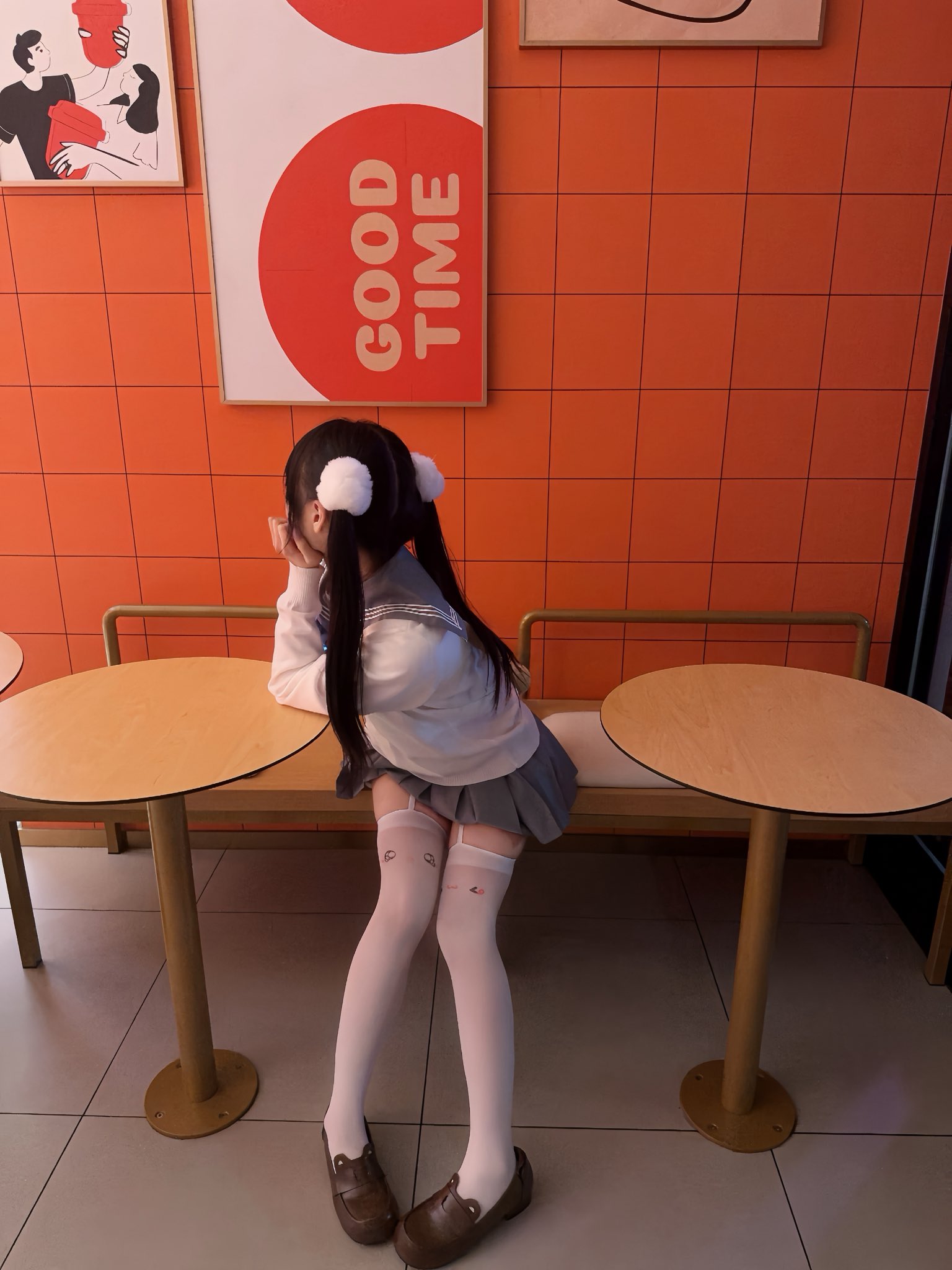 女孩坐在一个凳子上,背后有一个标志说“好时机”。