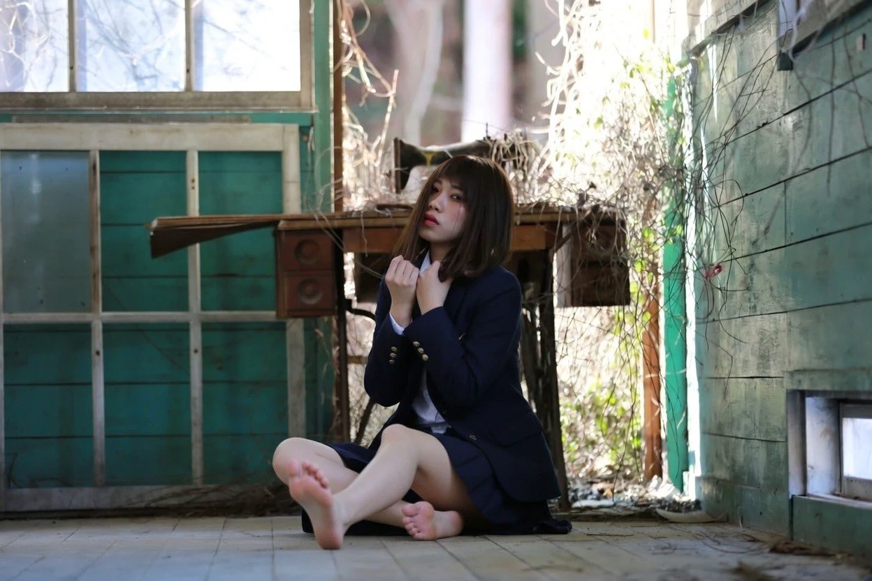 穿蓝色夹克的女人坐在地板上。