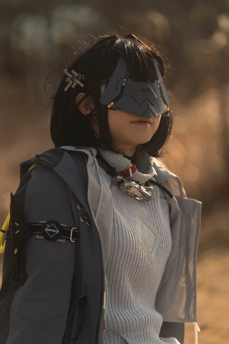 戴着面具和灰色夹克的女人。