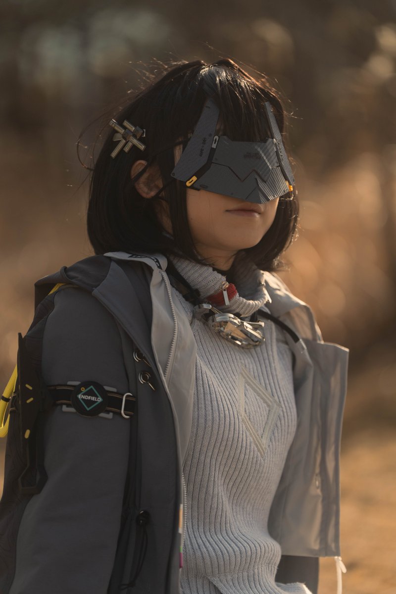 戴着面具和灰色夹克的女人。