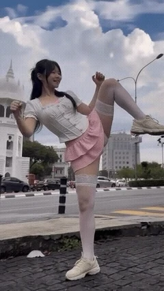 穿着粉红色的裙子和白色裤子的女人把她的腿抬起来。