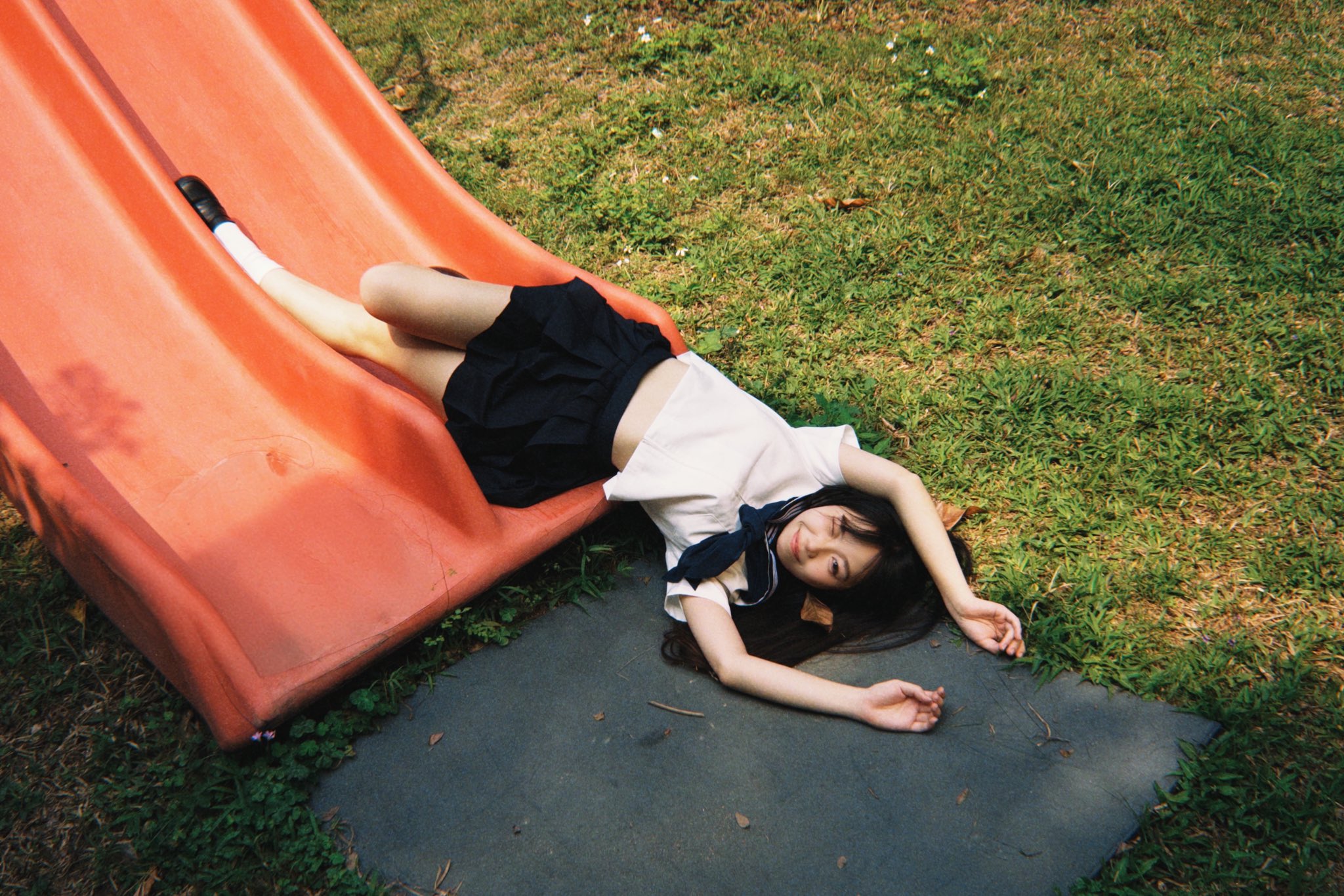 女孩躺在一个滑板上。