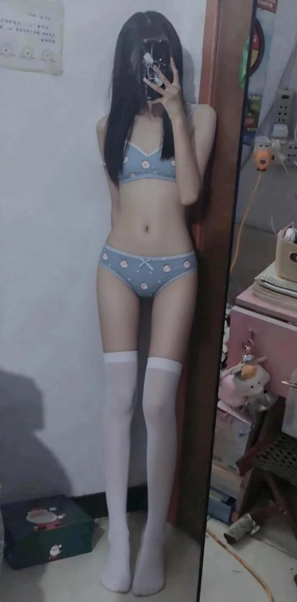 女人穿着蓝色比基尼和白色裤子。