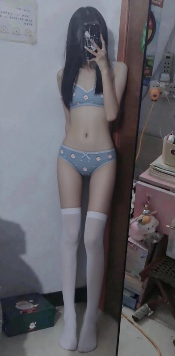 女人穿着蓝色比基尼和白色裤子。