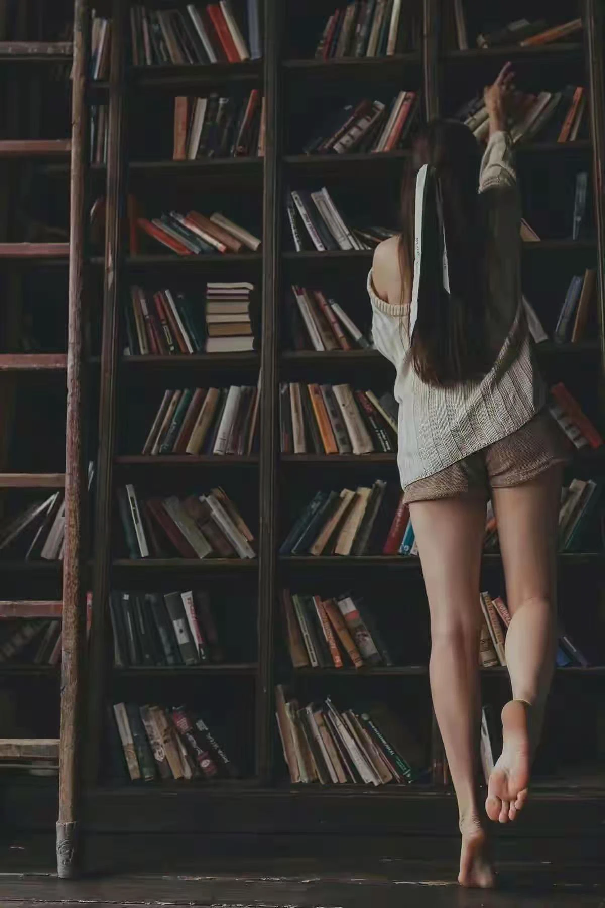 穿短裤的女人站在书架前面。