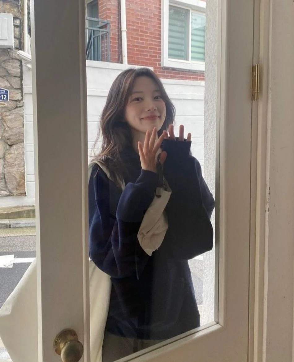 长头发和蓝衬衫的女人在相机前微笑。