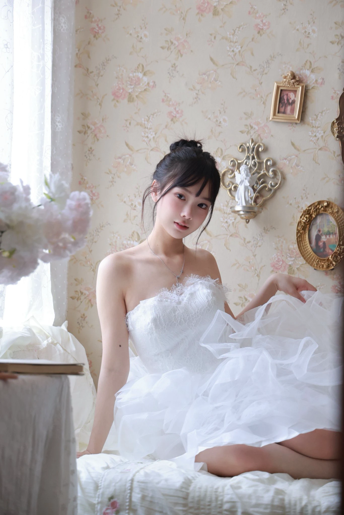 白い服を着た女性が床に座る。