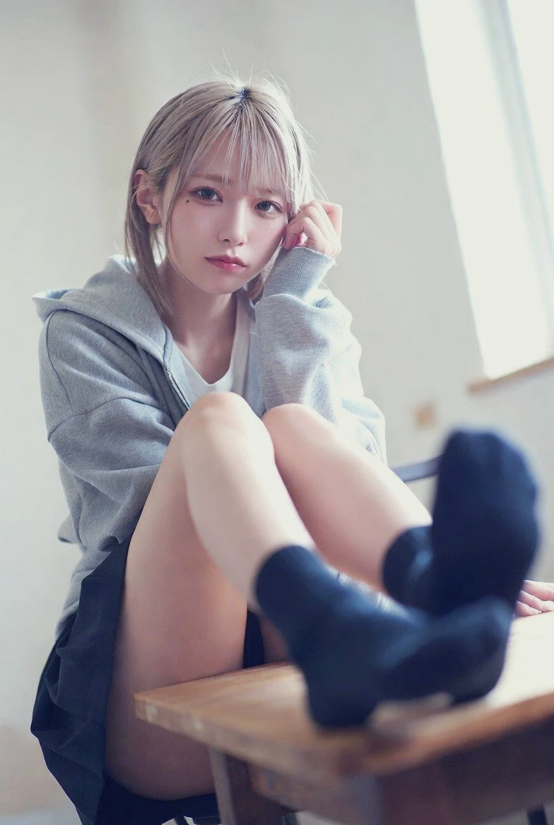 穿着灰色帽子和黑色袜子的女孩坐在桌子上。