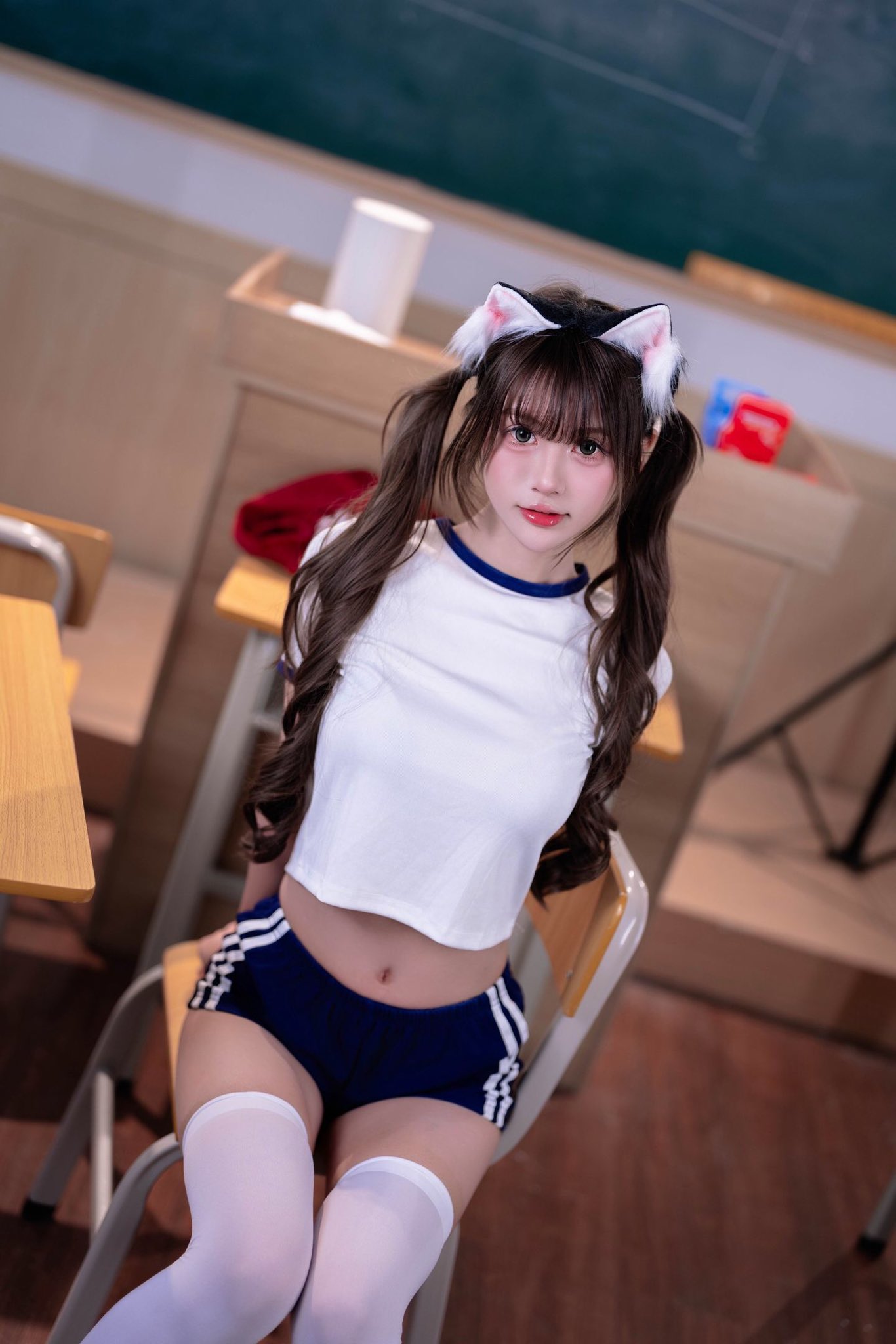 一位穿着红色衬衫和猫耳朵的女孩指向相机。