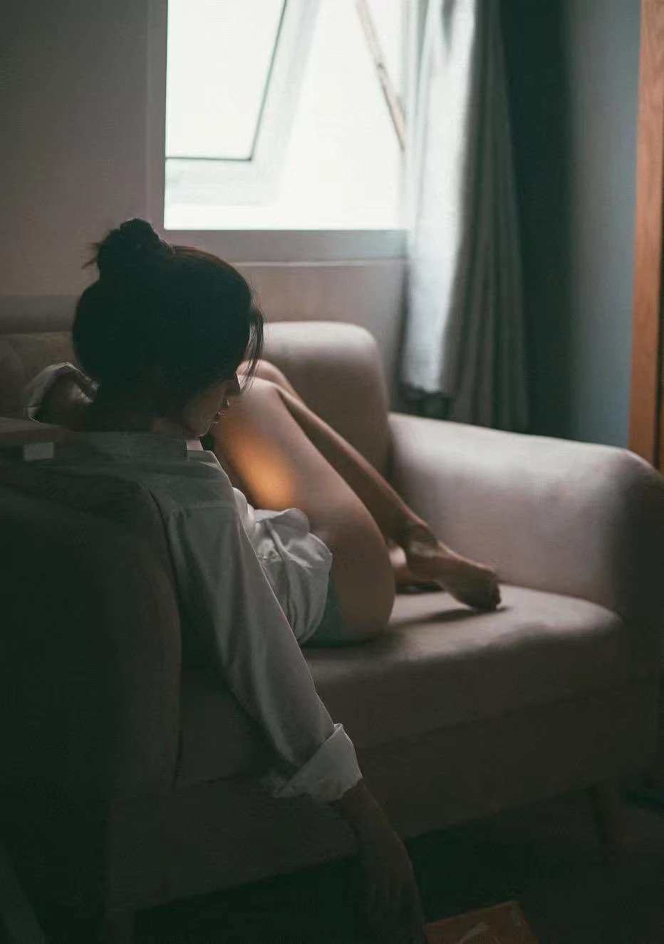 女人坐在沙发上,双腿交叉。