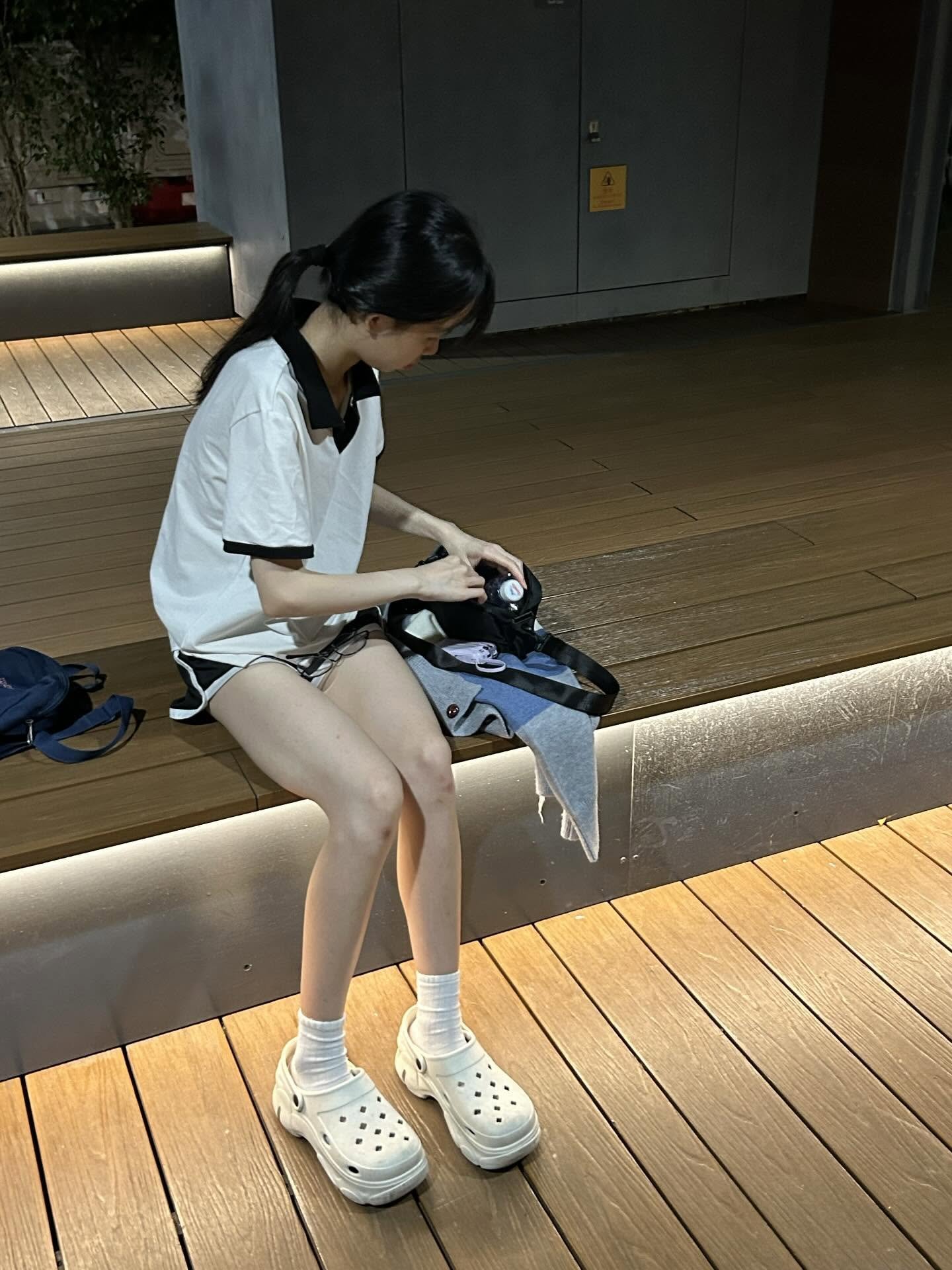 女人坐在椅子上,带着相机。