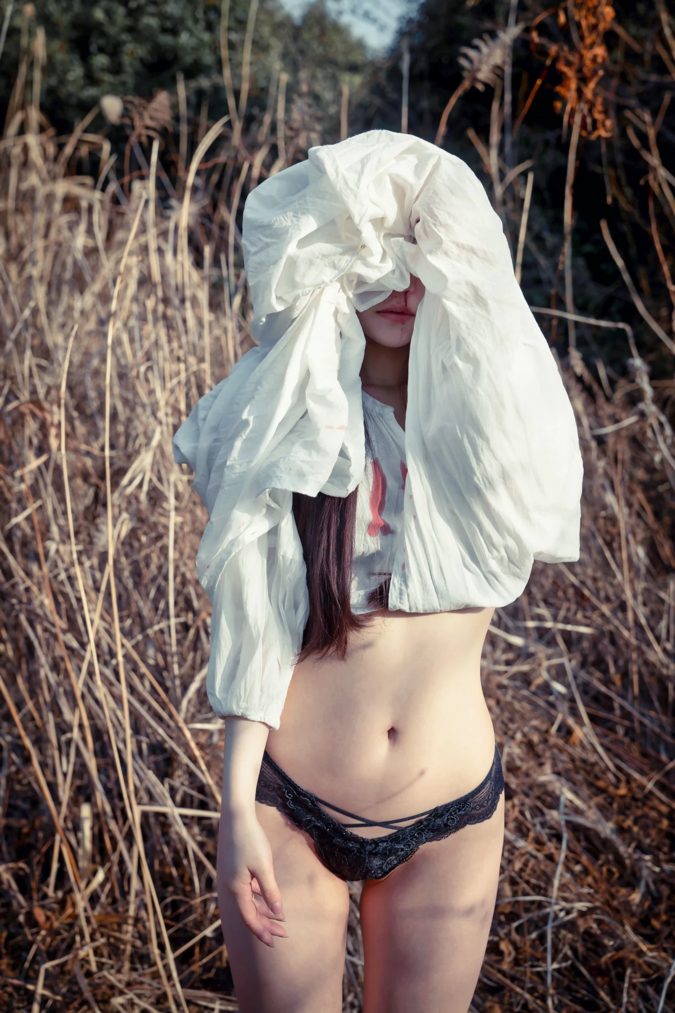 穿着白色衬衫和黑色内衣的女人,头上有一件白色布。