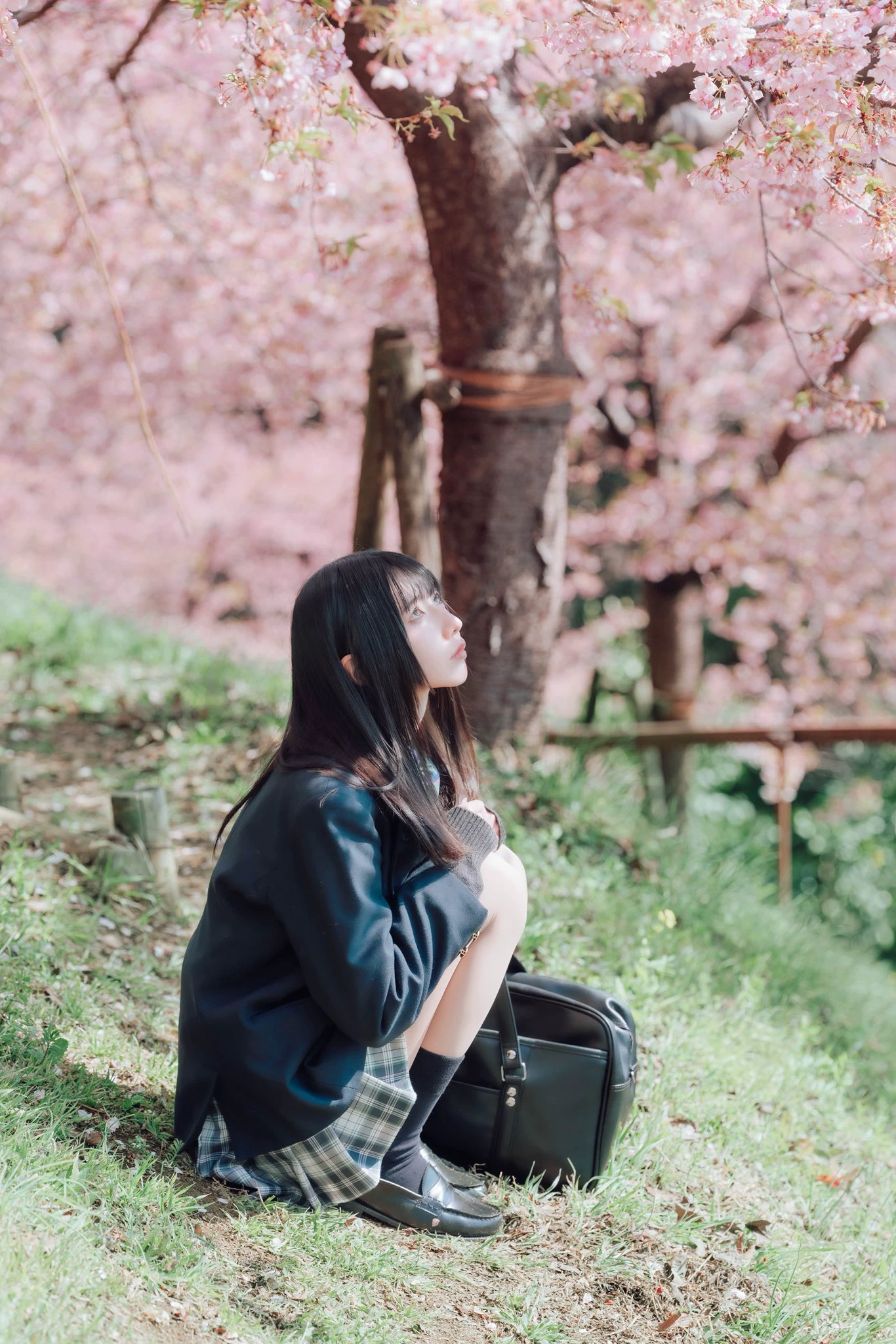 穿着黑色夹克和裙子的女人坐在地上。