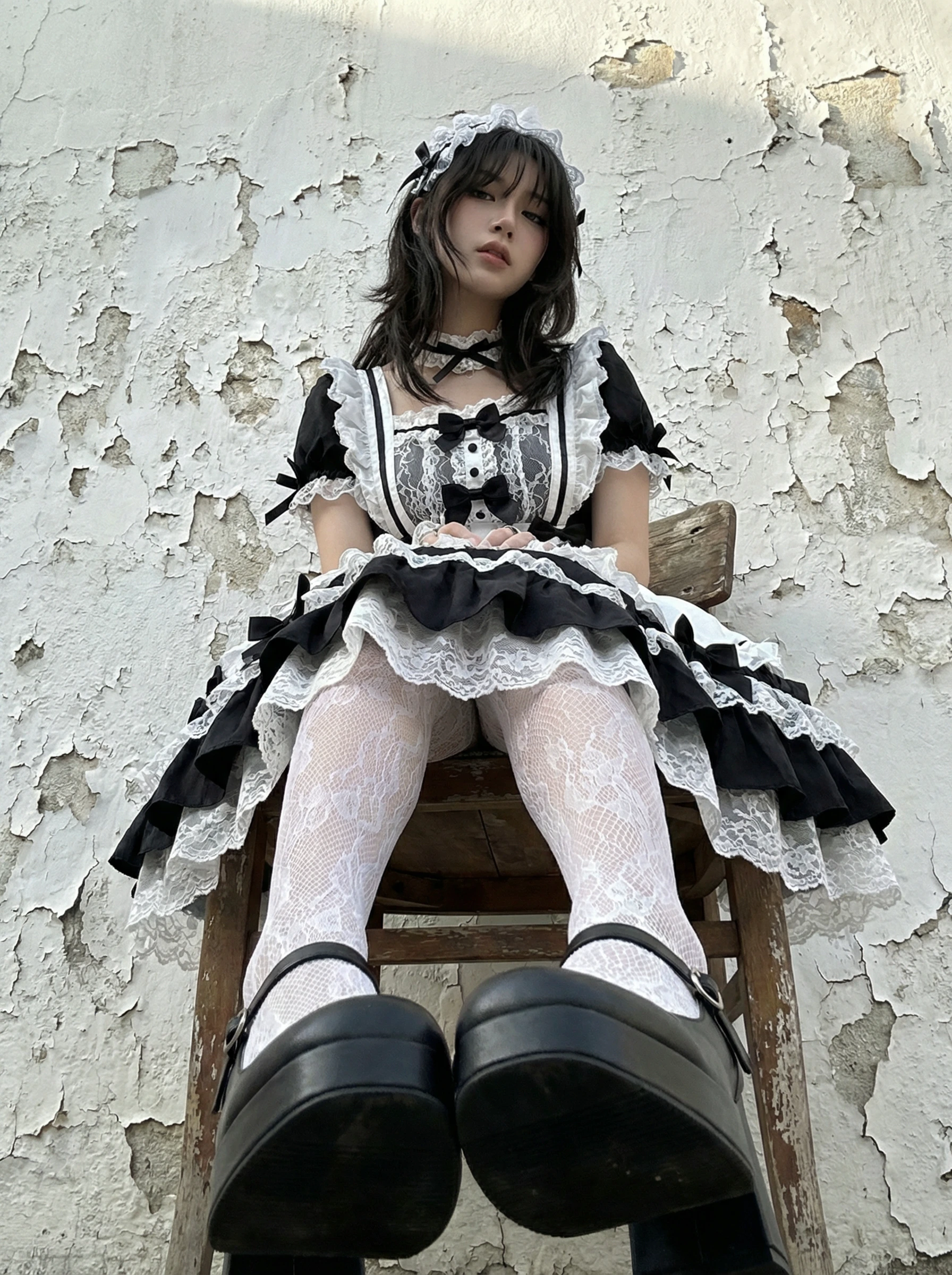 穿着女仆的服装的女人坐在椅子上。