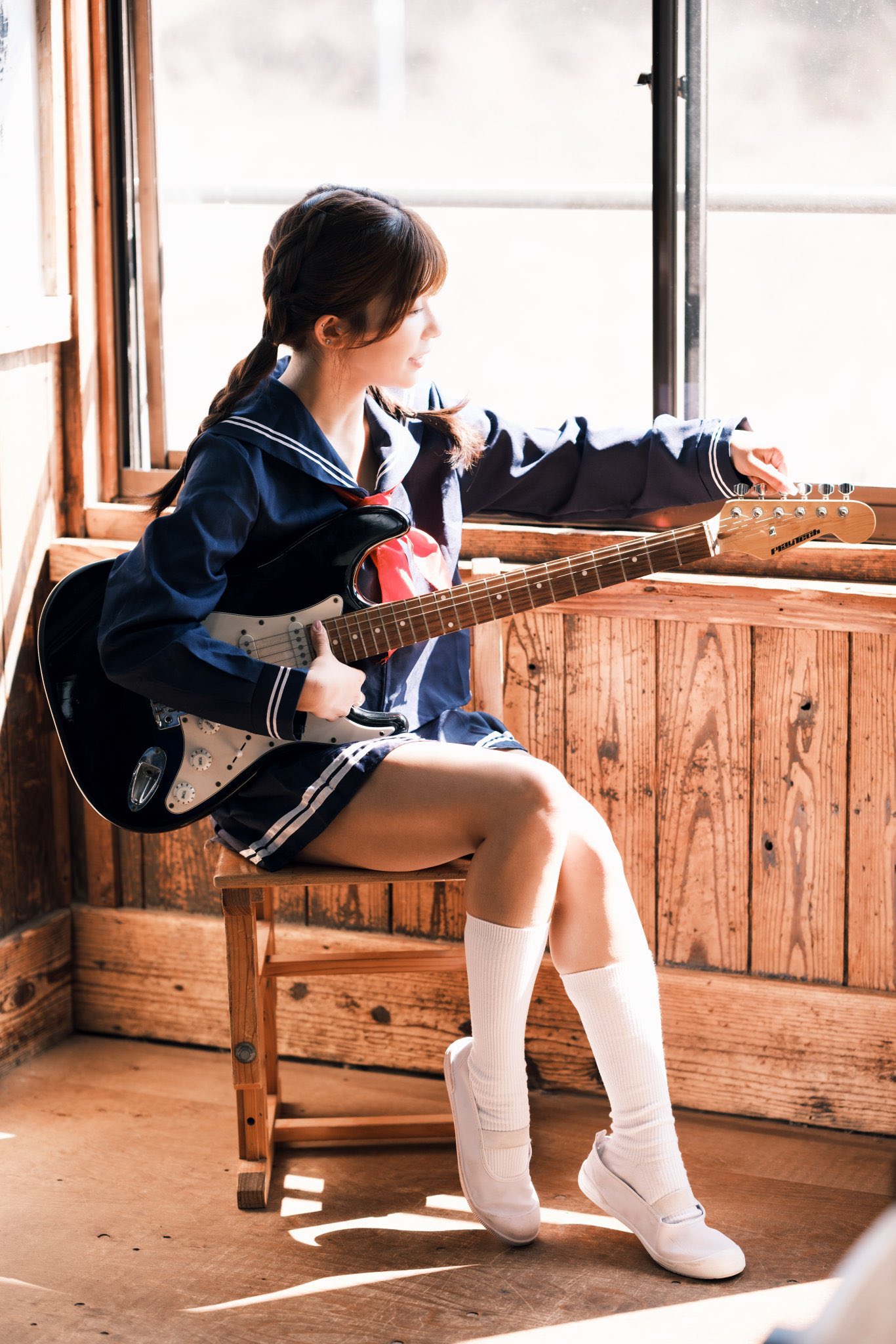 穿着蓝色衣服的女孩弹吉他。